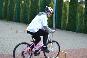 Chłopiec jadący na rowerze zatrzymuje sie przez przeszkodą