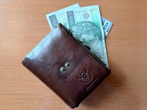 brązowy portfel, gotówka oraz część karty płatniczej - zdjęcie poglądowe