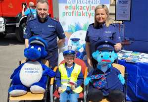 policjanci wraz z chøpcem w mudnurze i maskotkami na pamiátkowym zdjéciu...