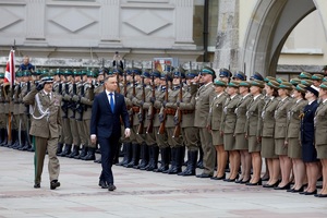 prezydent polski idzie wzdłuż stojących w szeregu strażników granicznych