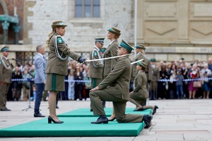 ceremonia pasowania na oficera, kobieta oficer opiera szablę na ramieniu strażnika granicznego