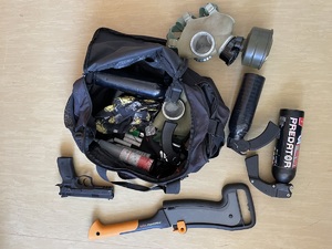 maczeta gazy pieprzowe maska przeciwgazowa pistolet gazowy leżące na podłodze oraz inne niebzepiczne przedmioty w torbie sportowej