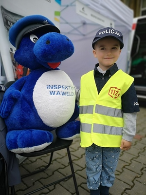 dziecko pozuje do zdjęcia z policyjną maskotką - Wawelkiem
