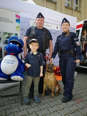 Policjanci, pies służbowy i Wawelek pozują do zdjęcia z dzieckiem