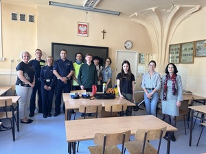 Grupowe zdjęcie uczestników spotkania, policjantów, strażnika miejskiego i Prezesa Prodriver