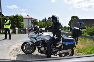 Policyjny motocyklista stoi na poboczu