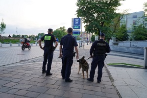 dwóch umundurowanych policjantów oraz strażnik miejski obserwujący ruch na jednej z krakowskich ulic