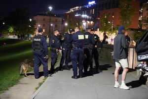 policjanci i strażnicy miesjscy stojący na Bulwarze Czerwieńskiego. Obok oraz w tle widać przechodniów — kopia