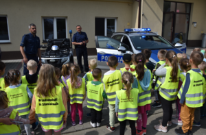Przedszkolaki ze Stanisławic oraz umundurowani policjanci stojący obok policyjnego quada i radiowozu