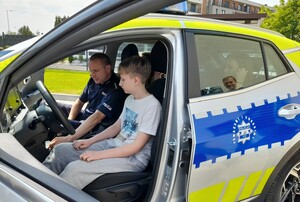 policjant prezentuje nastolatkowi wnętrze radiowozu