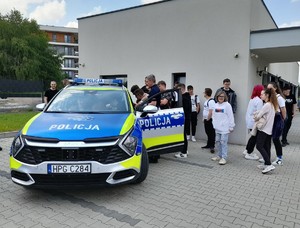 policjant prezentuje młodziezy radiowóz