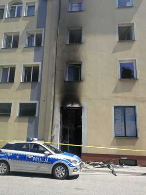 radiowóz stojący przed budynkiem, w którym doszło do pożaru