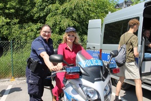 kobieta siedząca na policyjnym motocyklu, obok stoi policjantka
