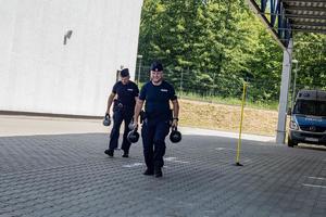 policjanci biegną z ciężarami za budynkiem