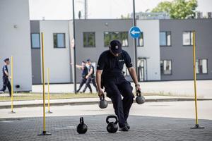 policjant z ciężarami omija tyczki