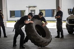 para policjantów przerzuca oponę od ciągnika