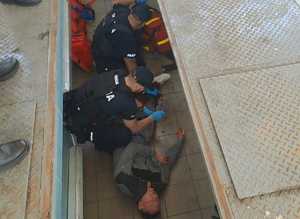 Policjanci opatrują nogę osobie, która udaje ranną