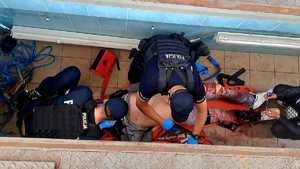Trzech policjantów opatruje nogę osobie, która udaje ranną