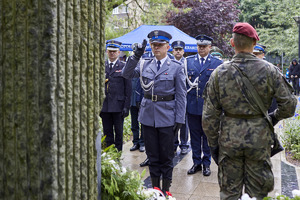 policjant i żołnierz oddają hołd pomordowanym