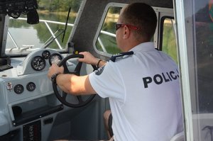 policjant prowadzący motorówkę po Jeziorze Dobczyckim