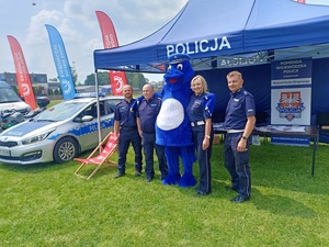 Policjanci z maskotką inspektora wawelka przy stanowisku profilaktycznym