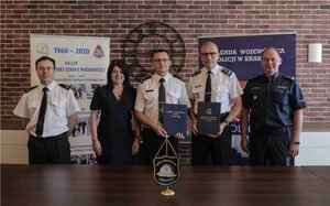 Komendant Wojewódzki Policji w Krakowie insp. Roman Kuster i mł. bryg. Marek Chwała wraz z osobami uczestniczącymi w podpisaniu porozumienia o współpracy