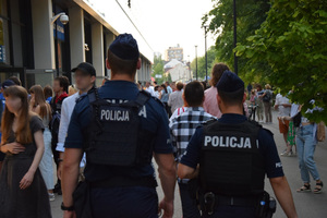 Patrol policji wsród tłumu przemieszczjącego się przed stadionem Wisły.