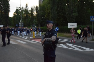 Policjant w trakcie zabezpieczenia pochodu zawodników. W tle widać reprezentantów Grecji