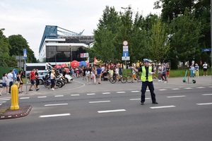 Policjant z ruchu drogowego kieruje ruchem na drodze przed stadionem Wisły.