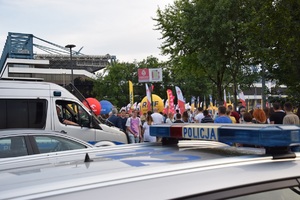 Tłum ludzi przechodzący koło radiowozów przy stadionie Wisły.