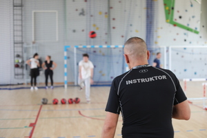 instruktor nadzoruje rzucanie piłką lekarską