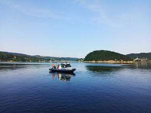 policyjna łódż na jeziorze, w tle Małpia Wyspa