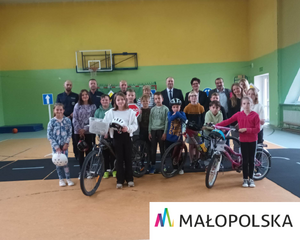 zdjęcie grupowe policjantów i uczestników mobilne miasteczko ruchu drogowego; na dole napis Malopolska