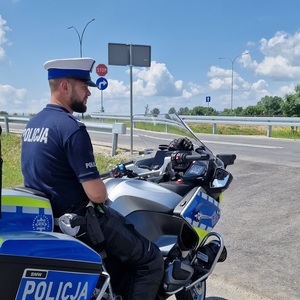 policjant ruchu drogowego na motocyklu nadzoruje ruch na drodze