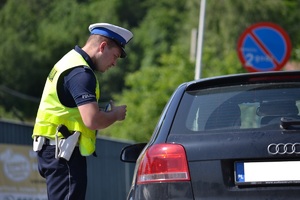 Policjant podczas rozmowy z kierującym zatrzymanym do kontroli