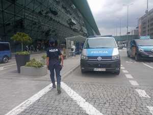 policjantka patrolująca rejon lotniska, obok zaparkowany radiowóz