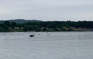 zalew na którym w tle widać pływającą łódź policyjna i kajakarzy rywalizujących
