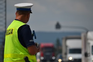 Policjant ruchu drogowego nadzoruje ruch na drodze
