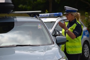 Policjantka ruchu drogowego objaśniająca kierowcy założenia akcji promującej bezpieczeństwo