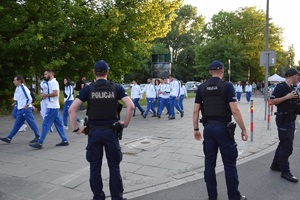 dwóch umundurowanych policjantów nadzorujących przejście zawodników na stadion na stadion przy ul. Reymonta