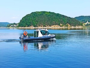 policyjna łódź na Jeziorze Rożnowskim w tle Małpia Wyspa