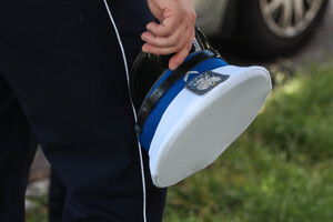 policjant trzyma w rękach czapkę policyjną
