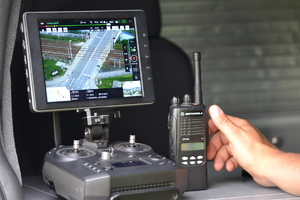 Wyświetlacz urządzenia sterującego dronem z podglądem obrazu z kamery drona - widokiem przejazdu kolejowego