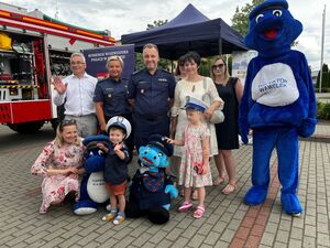 uczestnicy pikniku wraz z policjantami i maskotkami policyjnymi na pamiątkowej fotografii