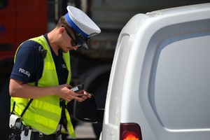 Policjant ruchu drogowego przeprowadzający badanie trzeźwości kierowcy