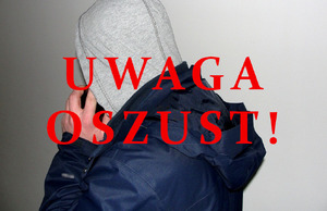 mężczyzna w bluzie w kapturem na głowie rozmawia przez telefon komórkowy  NAPIS UWAGA OSZUST