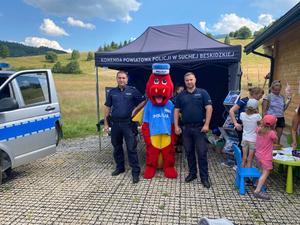 Dzielnicowy z policjantem pozujący do zdjęcia z maskotką polickiem