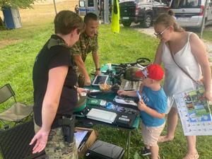 funkcjonariusze Strazy granicznej prezentujacy sprzęt mamie i jej kilkuletniemu synowi