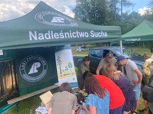 osoby stojące przezd namiotem nadlesnictwa biorace udział w konkursach wiedzy