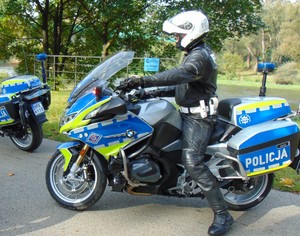 policjant na motocyklu w tle drzewa